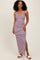 woman wearing a navy and white striped maxi dress with a side slit and smiling at the camera