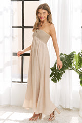 woman wearing a beige strapless maxi dress with a smocked bodice and flowing skirt