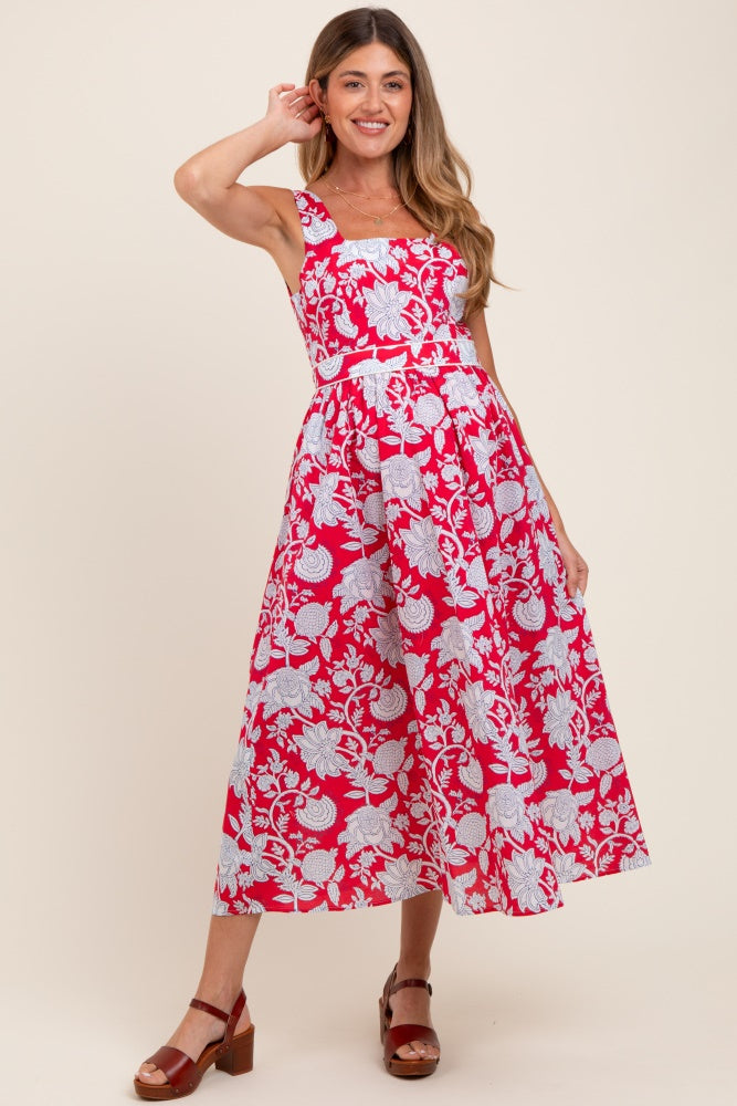 woman wearing a pink and white floral print maternity dress with a fitted bodice and flared skirt