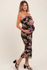 woman wearing a black floral strapless maternity dress and holding her baby bump
