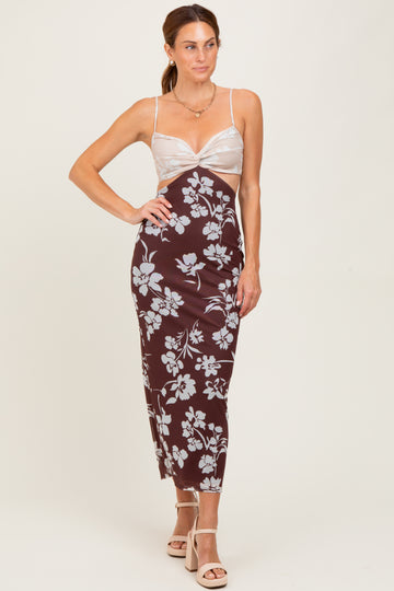 woman wearing a brown floral midi dress with a sheer bodice and spaghetti straps, standing in a neutral background