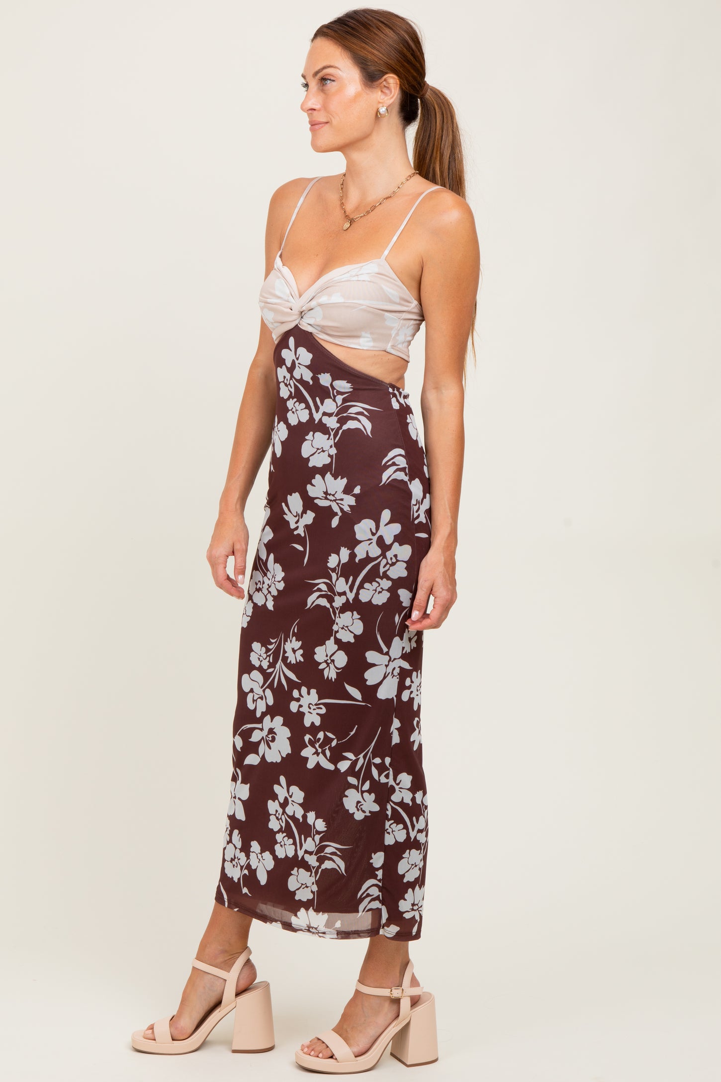 woman wearing a brown floral print maxi dress with a sheer top and strappy sandals