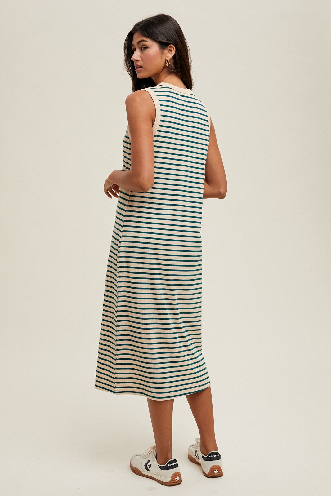woman wearing a green and white striped sleeveless midi dress, seen from the back