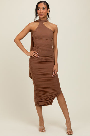 woman wearing a brown one-shoulder ruched midi dress with a side slit and heels