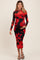 woman wearing a red and black floral maternity dress with long sleeves and a fitted silhouette, holding her baby bump