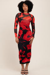 woman wearing a long sleeve black dress with a red floral print and a fitted silhouette