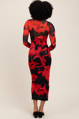 woman wearing a red floral midi dress with long sheer sleeves and a fitted silhouette, view from the back