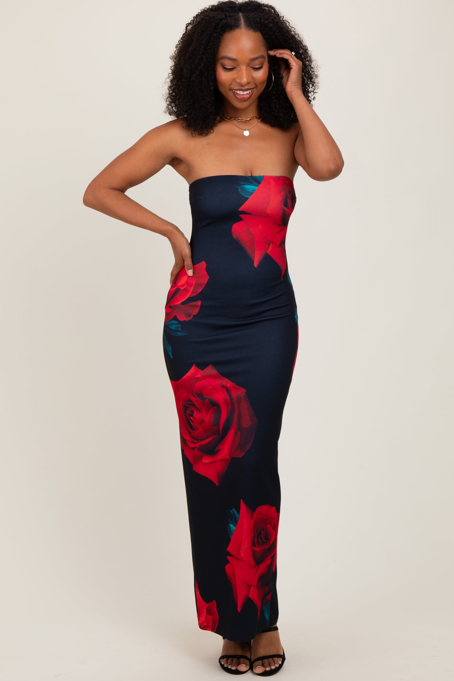 woman wearing a strapless navy blue maxi dress with red rose prints