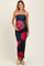 woman wearing a navy blue strapless maternity dress with red rose prints and holding her baby bump
