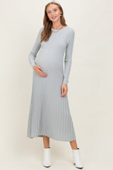 woman wearing a light gray ribbed long sleeve maternity dress and holding her baby bump