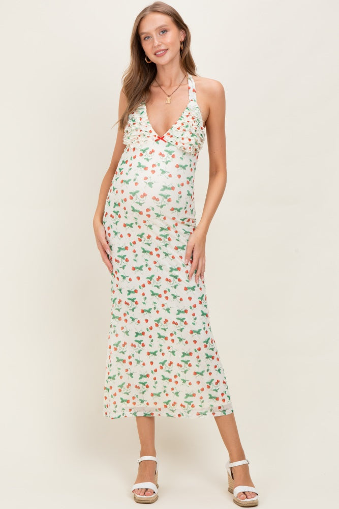 woman wearing a floral halter neck maternity dress with a fitted silhouette and a visible baby bump