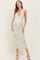 woman wearing a floral halter neck maternity dress with a fitted silhouette and a visible baby bump