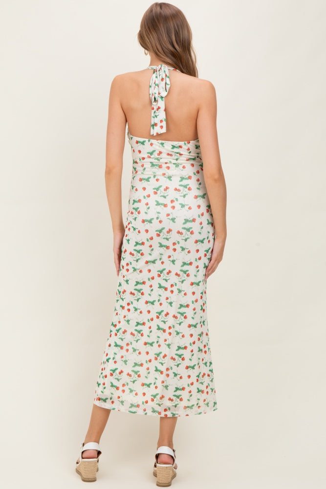 woman wearing a floral print maternity maxi dress with a halter neck and tied back detail