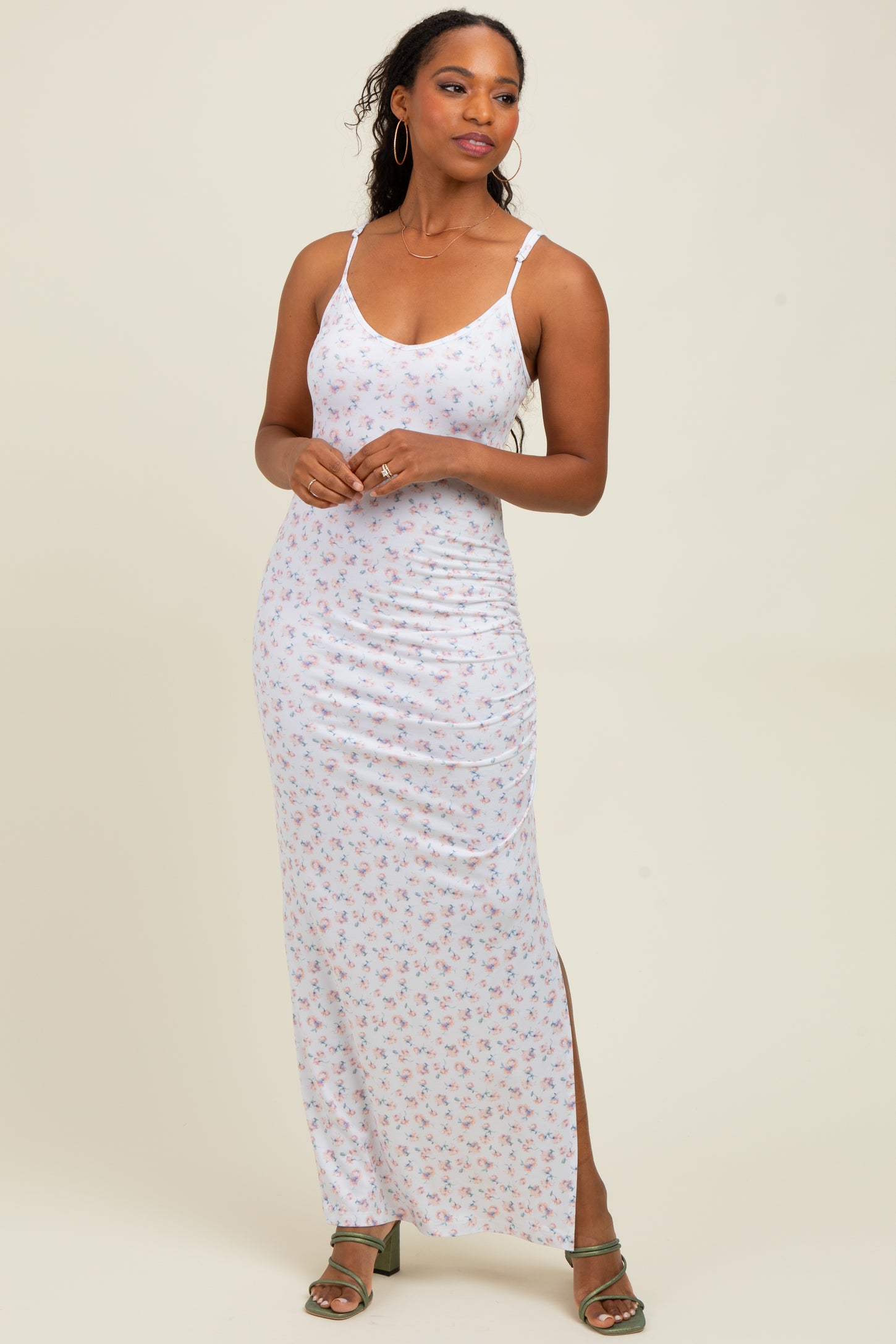 woman wearing a white floral maxi dress with side slit and thin straps