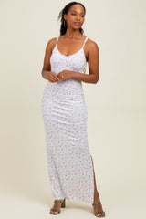 woman wearing a white floral maxi dress with side slit and thin straps