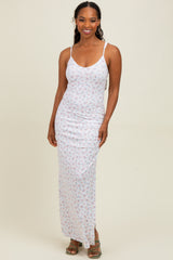 woman wearing a white floral maxi dress with thin straps and a fitted silhouette