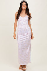 woman wearing a light pink floral maxi dress with spaghetti straps and a fitted silhouette