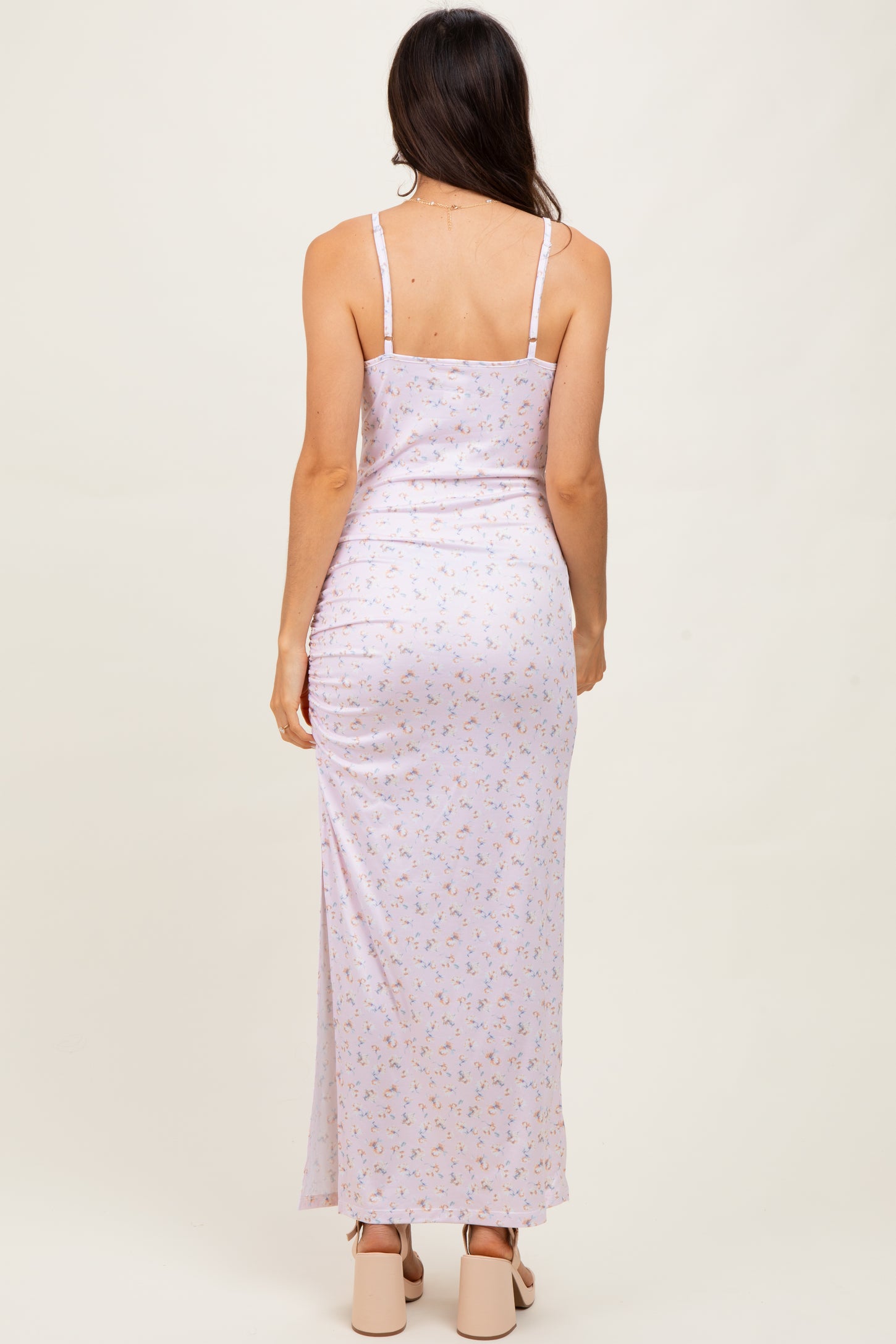 woman wearing a back view of a light purple floral maxi dress with thin straps