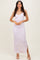 woman wearing a light purple floral maxi dress with a side slit and spaghetti straps