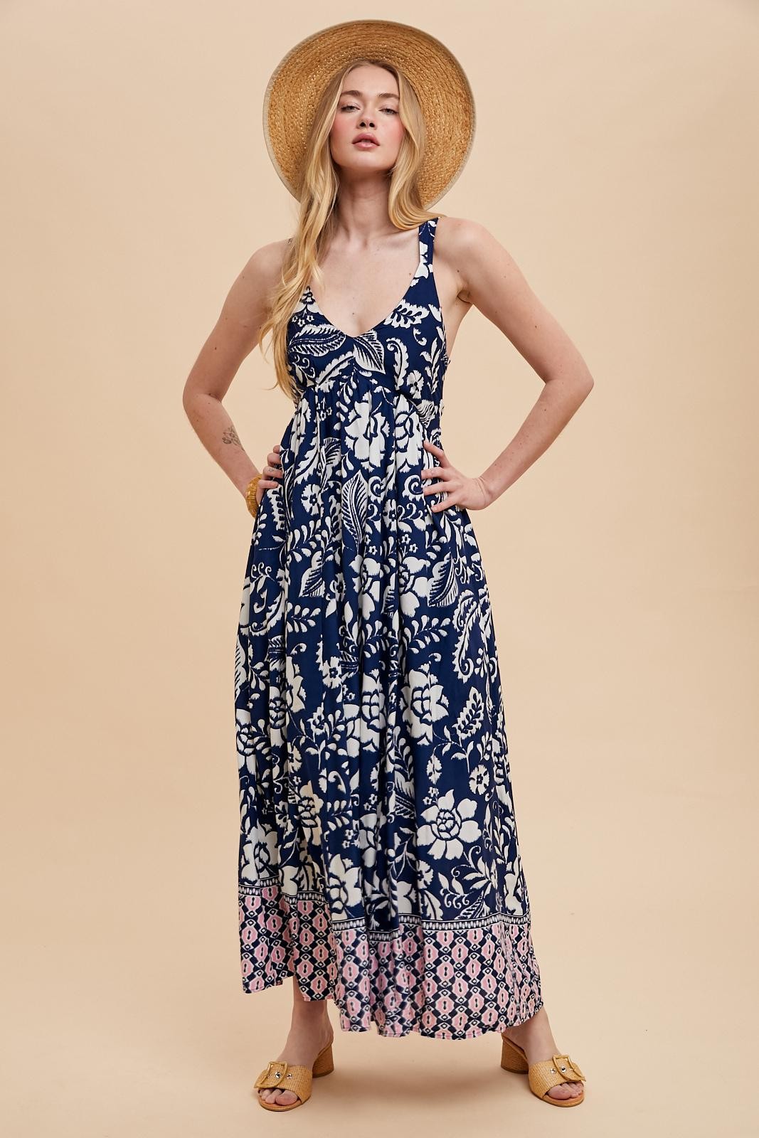 woman wearing a navy blue floral maxi dress with a split hem and pink detailing, showcasing a relaxed summer style