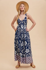 woman wearing a navy blue floral maxi dress with a split hem and pink detailing, showcasing a relaxed summer style