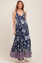 woman wearing a navy floral print maternity maxi dress with a pink patterned hem and visible baby bump