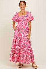 woman wearing a pink floral maxi dress with puff sleeves and pockets, styled with beige sandals