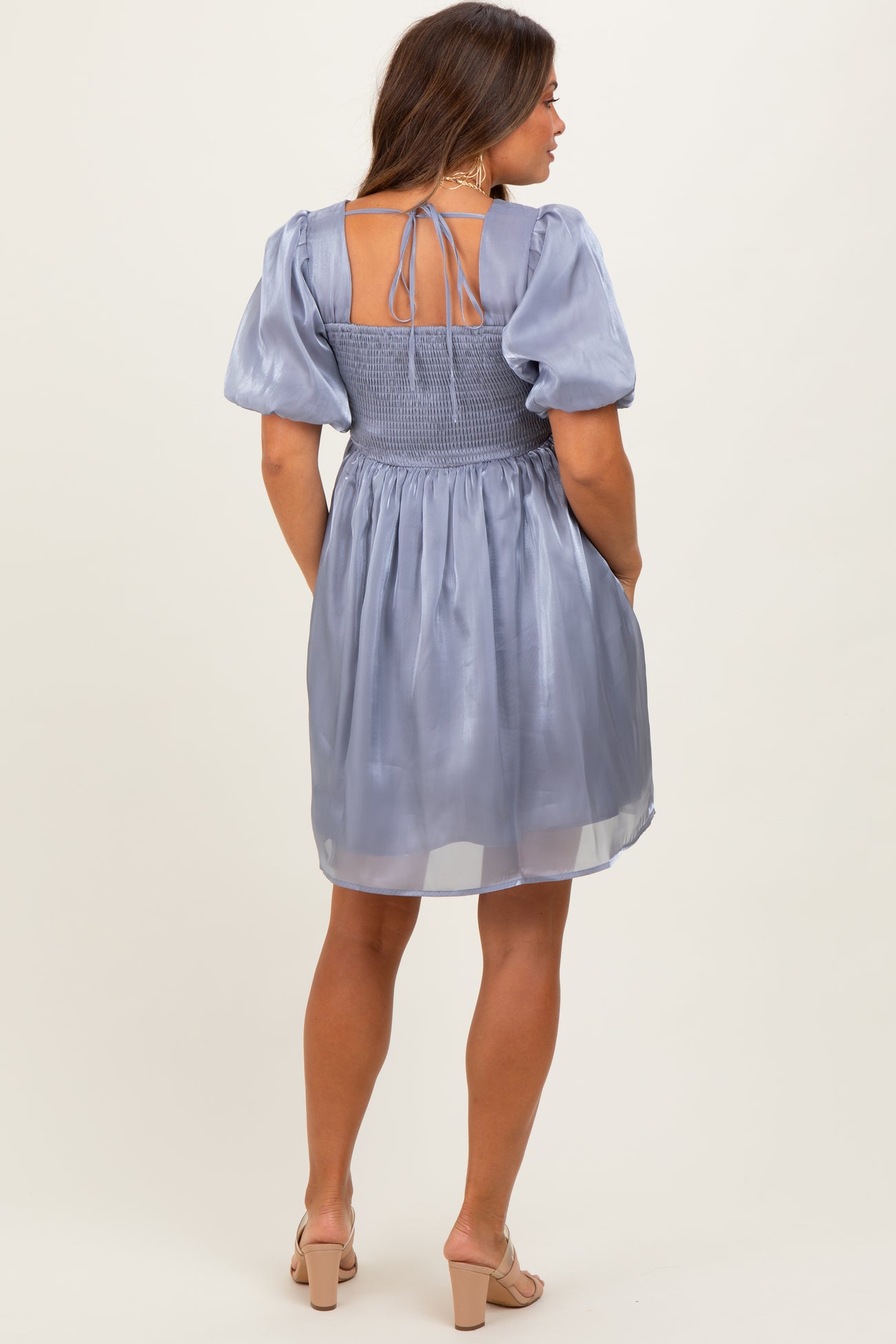 woman wearing a light lavender maternity dress with a smocked back and puff sleeves, showing a relaxed fit