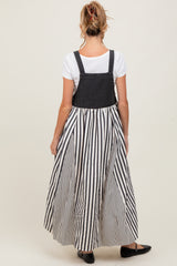 woman wearing a black and white striped maternity maxi dress with a denim top and back, showing off her baby bump
