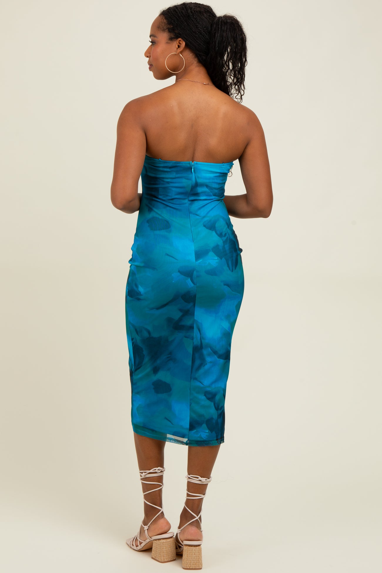 woman wearing a teal strapless midi dress with a fitted silhouette and a back zip closure