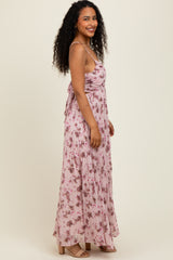 woman wearing a light pink floral maxi dress with spaghetti straps and gathered detailing, standing sideways