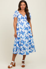 woman wearing a blue floral pattern maternity dress with short sleeves and ruffle hem