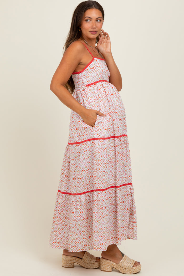 woman wearing a pink and white patterned maternity maxi dress with pockets and a visible baby bump