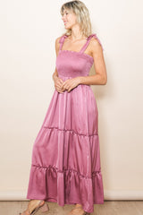 woman wearing a dusty pink maxi dress with smocked bodice and tie shoulder straps