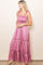 woman wearing a dusty pink maxi dress with smocked bodice and tie shoulder straps