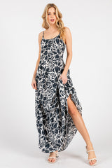 woman wearing a white and navy floral maxi dress with a high slit and spaghetti straps