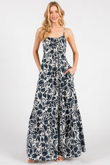 woman wearing a navy and white floral maxi dress with a ruffled hem and pockets