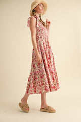 woman wearing a pink floral maxi dress with ruffled straps and a tiered skirt, paired with tan slide sandals and a straw hat