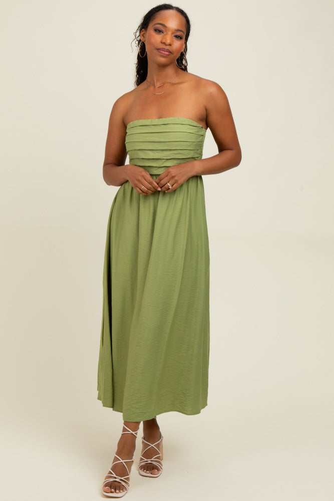 woman wearing a strapless olive green maxi dress with layered detailing and a side slit