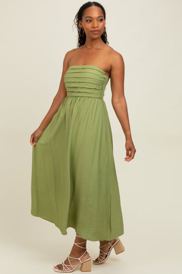 woman wearing a sleeveless green maxi dress with tiered detailing and a flowing skirt