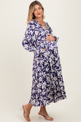 woman wearing a navy blue floral maternity dress with long sleeves and a baby bump visible