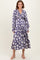 woman wearing a floral long sleeve purple maxi dress with a v-neck and gathered waist detail