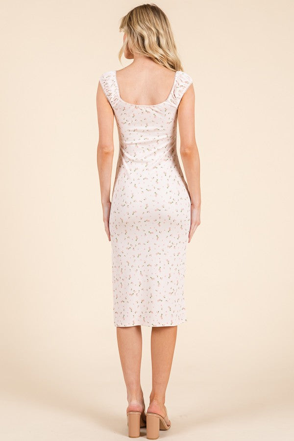 woman wearing a fitted blush pink midi dress with floral print and ruffled shoulder straps, viewed from the back