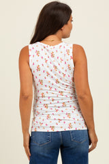woman wearing a white sleeveless maternity top with a floral print and a fitted style, from the back