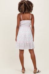 woman wearing a floral maternity dress with a smocked bodice and tiered ruffle hem, showing her back