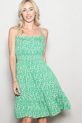 woman wearing a green floral sundress with smocked bodice and tiered skirt