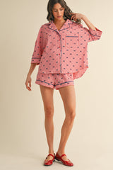 woman wearing a red and white checked pajama set with a button-up shirt and shorts, paired with red flats