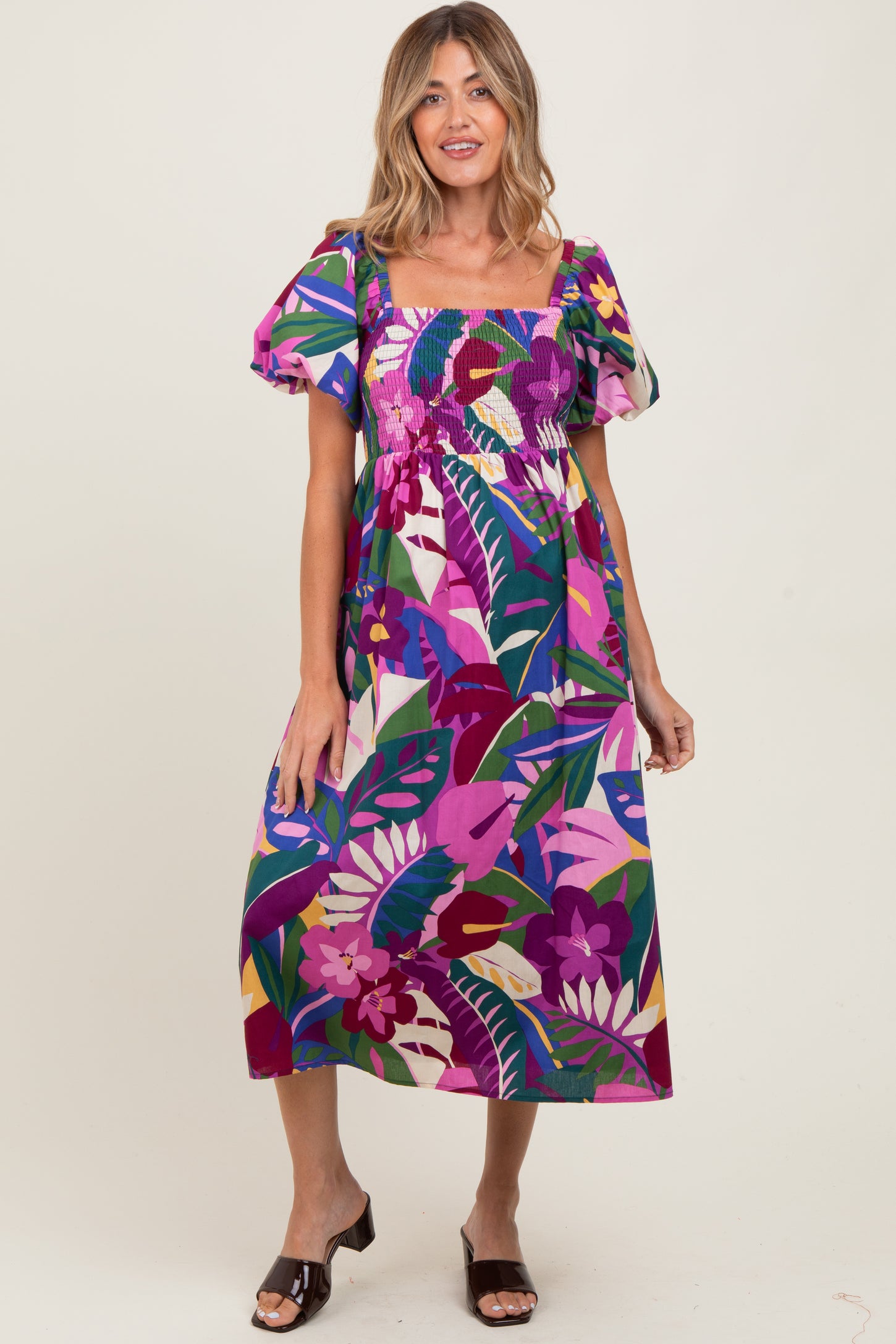 woman wearing a colorful floral maternity dress with puff sleeves and a square neckline