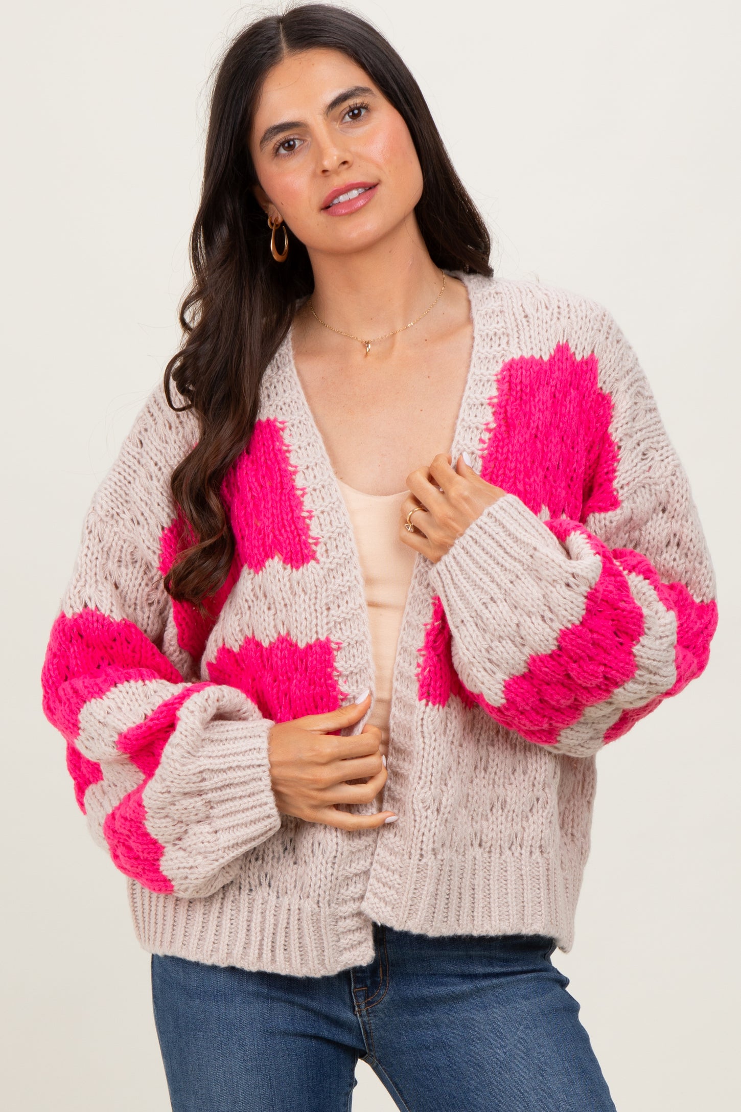 woman wearing a beige cardigan with bright pink floral patterns and puffed sleeves
