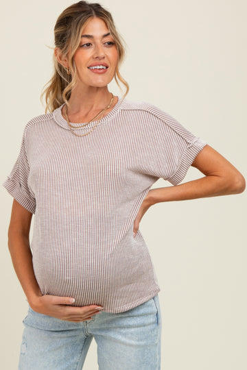 woman wearing a striped short sleeve maternity top and holding her baby bump